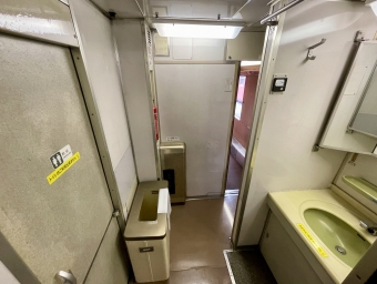 ニュース画像：1号車・車端部に設けられたトイレ(和式)と洗面台