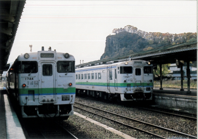 鉄道乗車記録の写真:乗車した列車(外観)(2)        「左が瀬戸瀬から乗車した列車。遠軽12:41着。13:00発網走行きになる。
奥の岩山はがんぼう岩。」