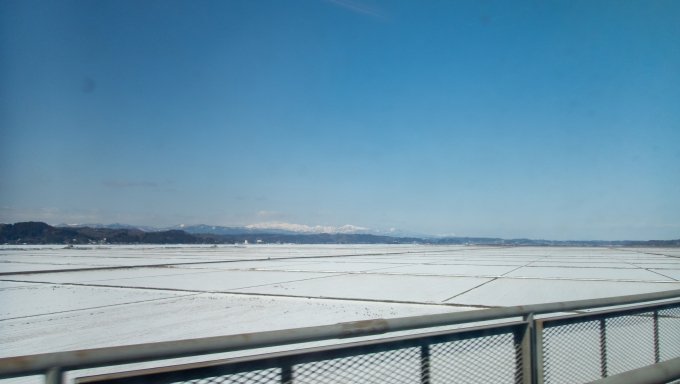 鉄道乗車記録の写真:車窓・風景(10)        「一見なんの変哲もない水田が広がっているように見えますが、ここは遊水地となっており北上川が氾濫した際には一面水浸しになります。
東北本線は堤防の外を通りますが、東北新幹線は日本一の長さを誇る「第一北上川橋梁」でここを突っ切っていきます。」
