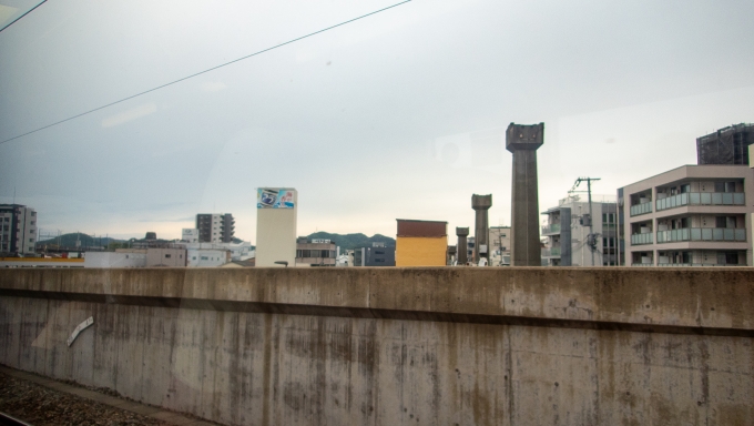 鉄道乗車記録の写真:車窓・風景(3)        「山陽姫路駅を出てすぐ、1974年に休止となったモノレールの支柱が目につきます。
足元にある建物と一体になっているため撤去できず、約50年経った今でもその姿が残されています。」