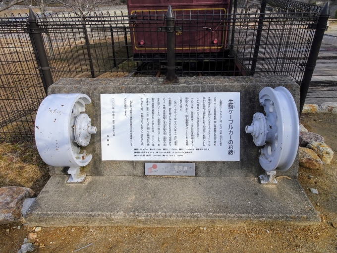 鉄道乗車記録の写真:旅の思い出(4)        「｢生駒ケーブルカーのお話｣の説明文の両側には、ケーブルカーの車輪が展示されています。」