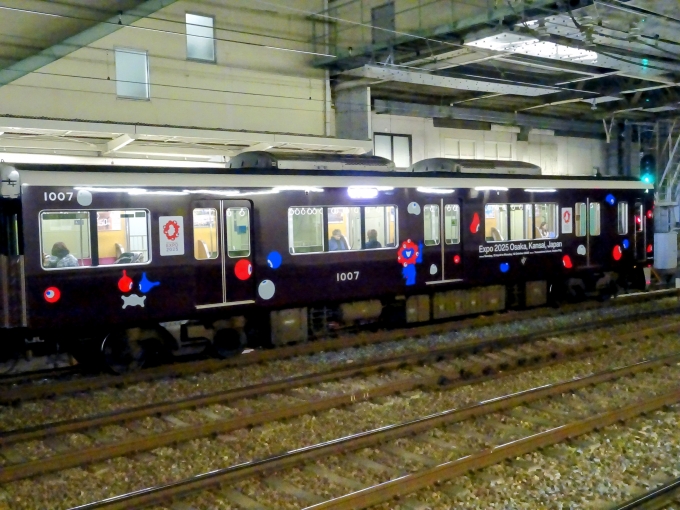 鉄道乗車記録の写真:列車・車両の様子(未乗車)(3)        「｢大阪・関西万博｣の装飾編成の先頭車です。手ブレ補正を掛けたのですが、下の段の小さい文字までは補正が効きませんでした。(英語で開催期間と開催地が記されています。)」
