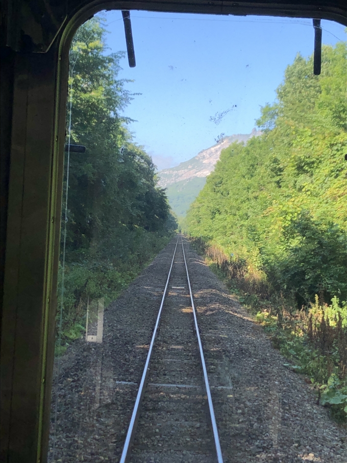 鉄道乗車記録の写真:車窓・風景(18)        「真っ直ぐな線路に両側の防雪林、正面には硫黄山がみえる。」