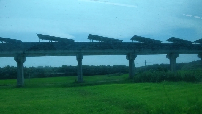 鉄道乗車記録の写真:車窓・風景(7)        「美々津駅から都農駅間の線路に沿うように全長約７ｋｍに渡って続く高架橋。
この景色を見た時、最初、何だろうと思いました。
調べたところ、この高架橋は1977年～1996年にリニアモーターカーの実験線として用いられたものです。以降は山梨の実用化実験線にバトンタッチされました。
現在は太陽光発電の場となっていて、約13000枚の太陽光パネルが設置されているとのことです。」